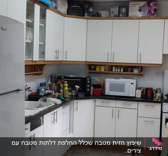 מטבח עם ארונות לבנים, מיקרוגל וטוסטר אובן
